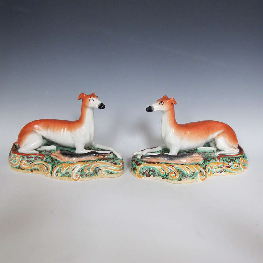 Rare large pair of Staffordshire recumbent greyhounds on rococo bases