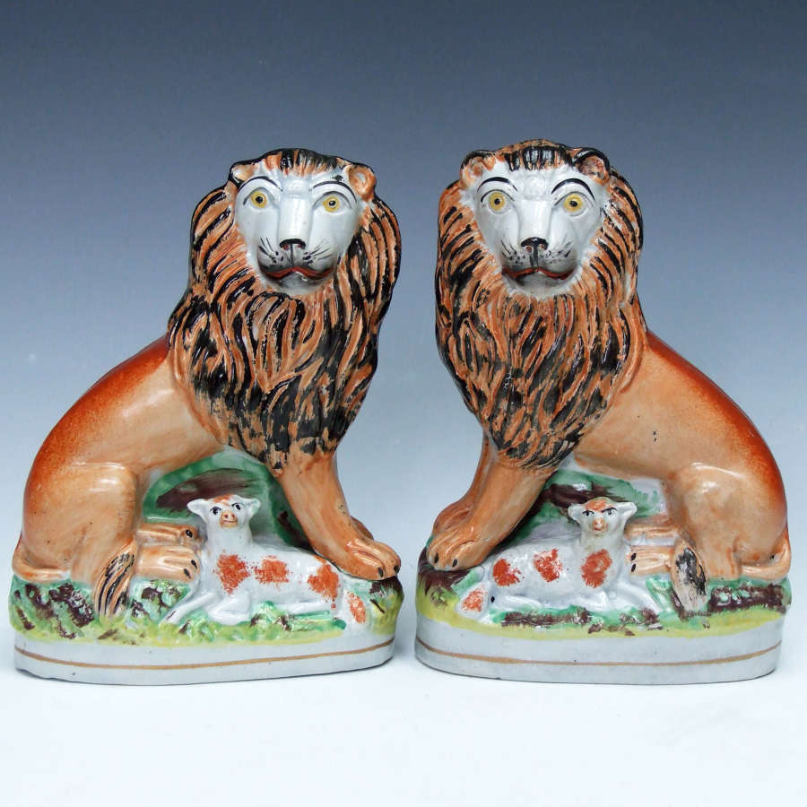 An extremely rare & charming pair of Staffordshire lion & lamb figures