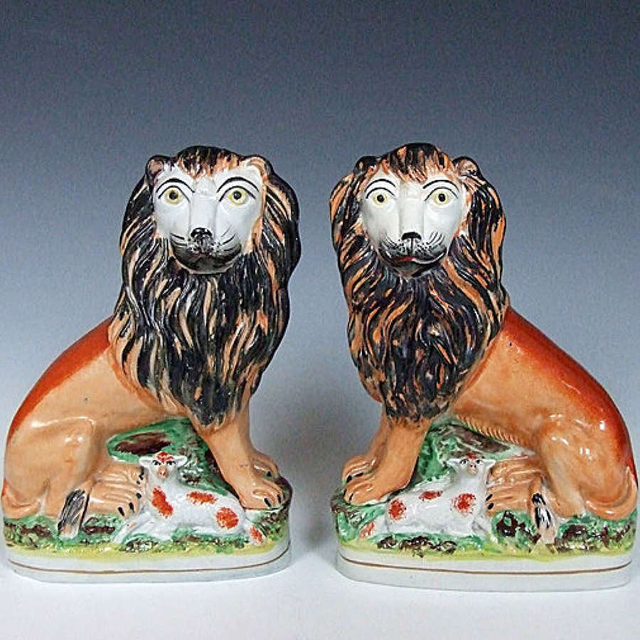 An extremely rare pair of Staffordshire lion & lamb figures
