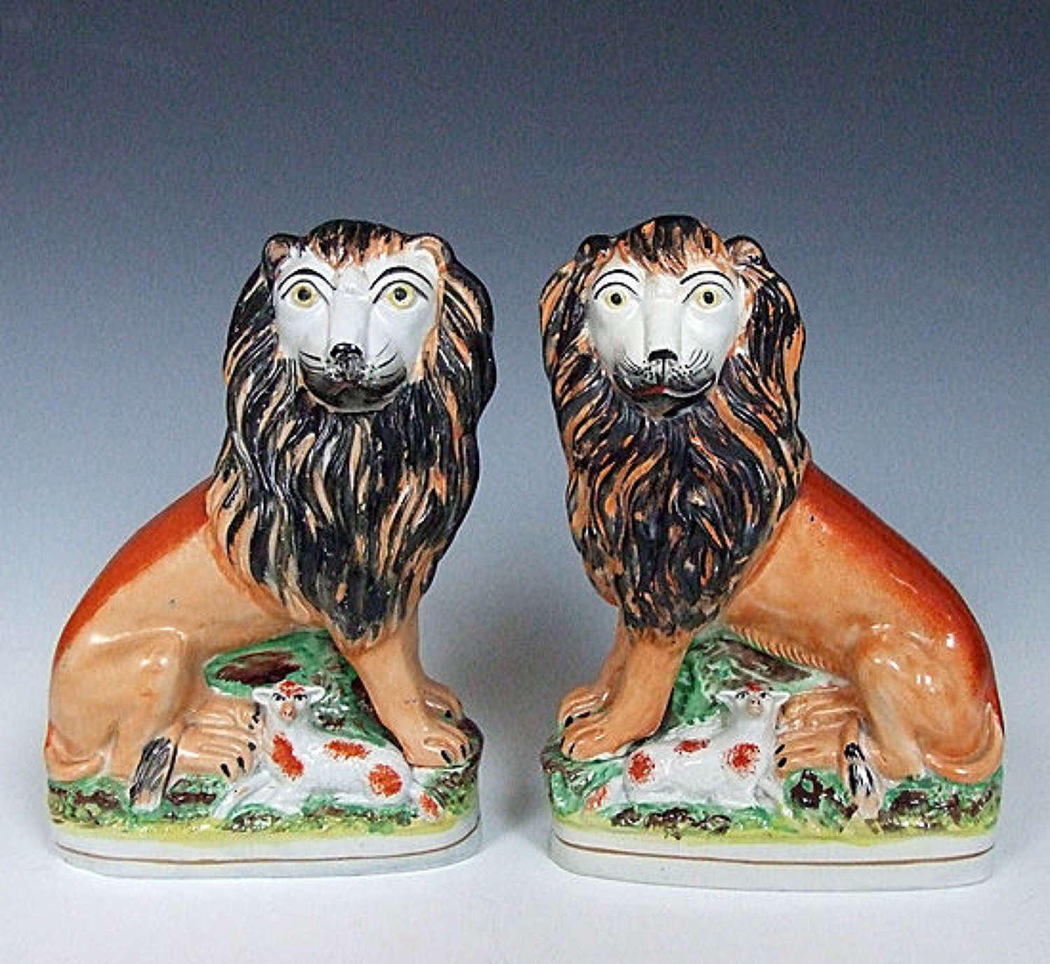 An extremely rare pair of Staffordshire lion & lamb figures